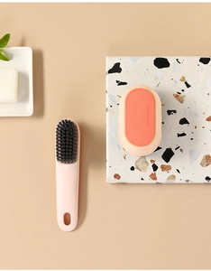 Close-up of pink long-handle shoe brush and oval scrubbing tool with fine bristles