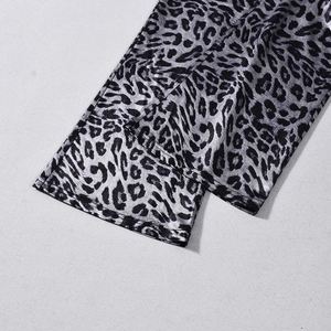 Detailed macro view of silver leopard print fabric with a smooth satin texture finish