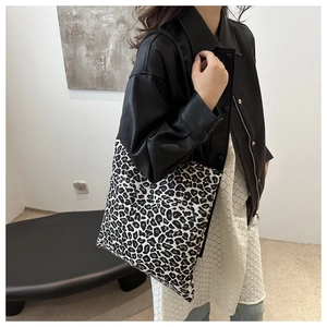 Detail shot of chic leopard print tote bag styled with a leather jacket and lace skirt