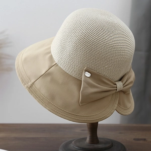 Detailed texture of beige straw weave and khaki fabric brim with elegant bow knot