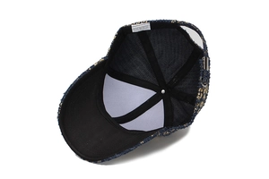 Dettaglio interno del cappellino in tweed con fodera nera ed etichetta di lavaggio
