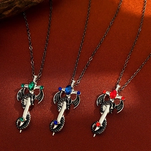 Gothic Drachen Kreuz Halskette mit roten blauen und grünen Edelsteinen auf Samtstoff