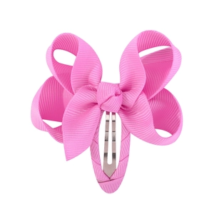 Detail of a bright pink bow hair clip with ribbed grosgrain texture and metal BB clip