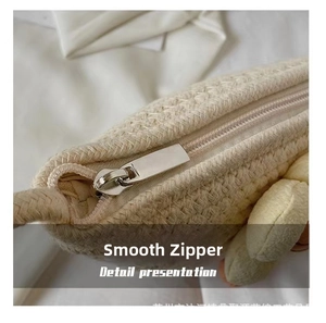 Detailed macro view of the smooth metal zipper and knit texture on the shell beach bag