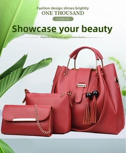 Three-piece red faux leather handbag set with tassels and metallic handles on white background