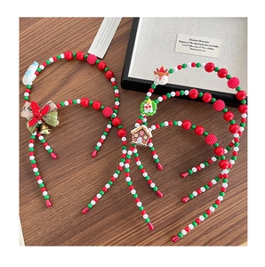 Detail view of handmade beaded Christmas headbands with charms on a wooden surface