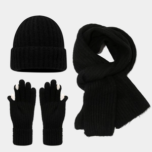 Close-up of black ribbed knit winter set with touchscreen gloves and long scarf