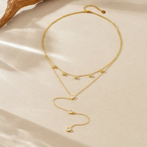 Double-layer gold plated stainless steel heart necklace with crystal fringe on sand background