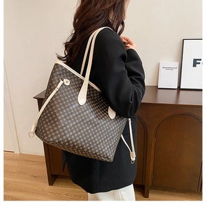 Detail of vintage tote bag with brown geometric print and beige straps worn on shoulder