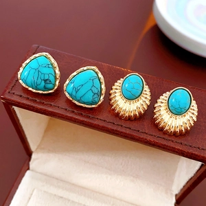 Detailed macro view of vintage turquoise stud earrings with ornate gold textured settings