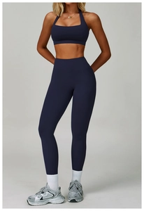 Detail of dark blue high-waist yoga leggings and halter neck top set with matte texture