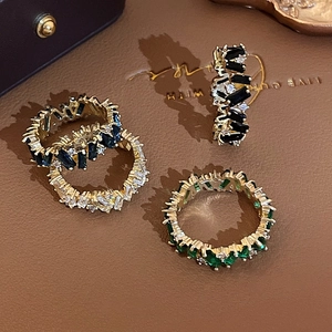 Macro detail of rectangular zircon rings in gold finish with multi-color gemstones