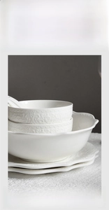 Detailed view of stackable white embossed ceramic tableware set with European patterns