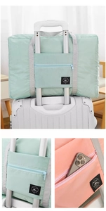 Detail showing the luggage trolley sleeve and front zipper pocket on a travel storage bag