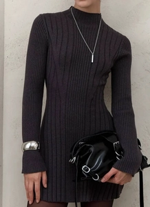 Detailed knit texture of a slim-fit high-neck dress with silver jewelry accessories