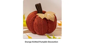 Close-up of an orange knitted pumpkin decoration with textured weave and felt leaf detail