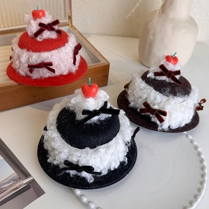 Close-up of cherry cream cake hair clips with velvet bows on a vintage wooden tray