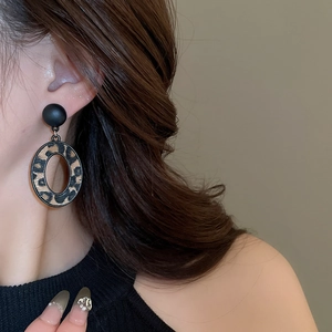 Gros plan de boucles d'oreilles géométriques léopard portées par un mannequin en hiver