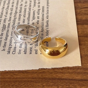 Minimalist thick curved open rings in gold and silver finish on vintage paper background