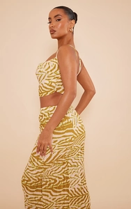 Detail showing green zebra print pleated fabric on a slim fit two-piece set outfit