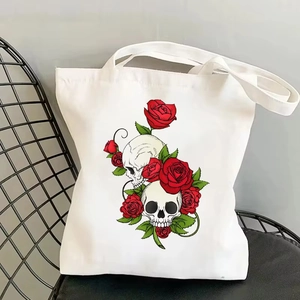 Vintage canvas tote bag with skull and rose print displayed on a black metal chair