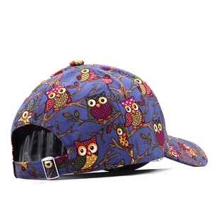 Detail of printed owl pattern baseball cap with adjustable metal buckle on purple fabric