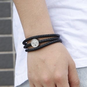 Three-layer black braided leather bracelet for men with silver cross charm on a wrist