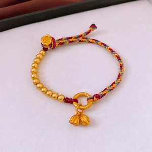 Detail of woven bracelet with gold lotus pod and beads on professional jewelry display