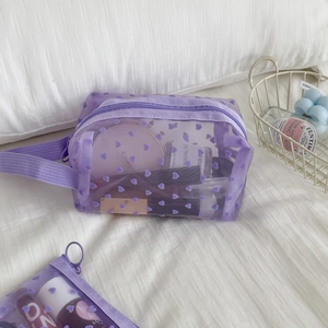 Detail of purple mesh makeup bag set with flocked hearts showing interior cosmetics