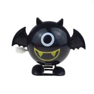 Macro detail of a black wind-up bat toy with a large eye and bat wings for Halloween gift