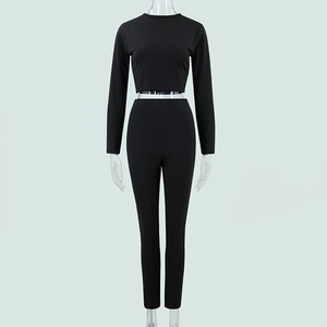 Détail d'un ensemble de sport noir deux pièces avec haut à col rond et pantalon taille haute