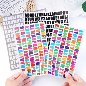 Detail view of colorful 0.5 inch alphabet stickers for jars and planners held by hand