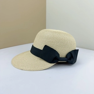 Detailed close-up of woven straw texture and elegant black ribbon bow on a sun hat