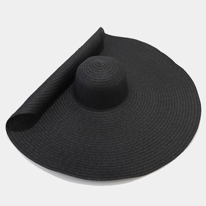 Dettaglio del cappello di paglia nero a tesa larga con trama intrecciata e flessibile