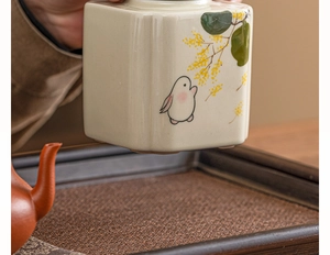 Close-up of hand-painted ceramic tea canister with rabbit and osmanthus pattern detail