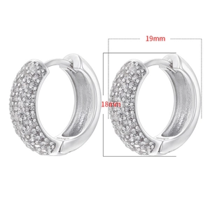 Dettaglio macro di orecchini argentati da 18mm con pavé di zirconi bianchi brillanti