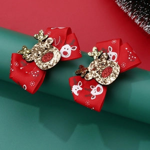 Detail of red handmade Christmas bow hair clips with gold sequin reindeer charm