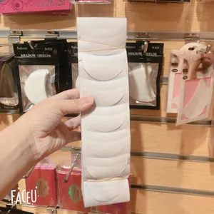 Close-up of semi-moon shaped non-woven eyeshadow shields for makeup protection