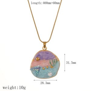 Detailed close-up of marine-themed enamel shell pendant with pearl on a gold snake chain