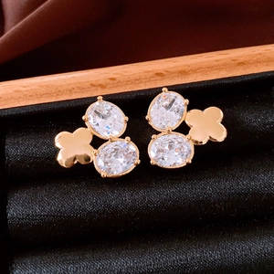 Detailaufnahme von 18K vergoldeten Blumenohrsteckern mit funkelnden Zirkonia-Kristallen