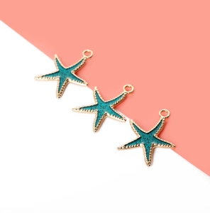 Macro shot of teal starfish pendants with gold edges for DIY jewelry making