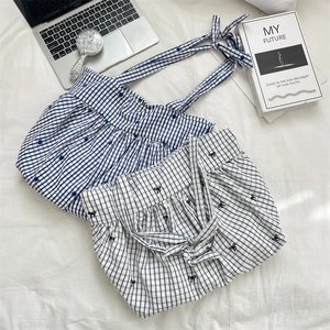 Detail of checkered tote bags with ribbon handles and small floral bow embroidery