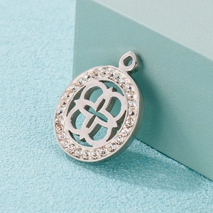 Silver hollow clover pendant with sparkling rhinestones on a minimalist blue background