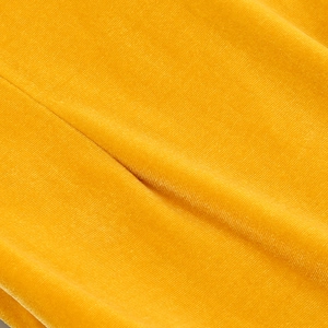 Vue macro du tissu en velours jaune vif montrant la texture fine et l'éclat de la soie