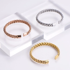 Detail of three-tone woven wire mesh cuff bracelets in gold, silver, and rose gold finish