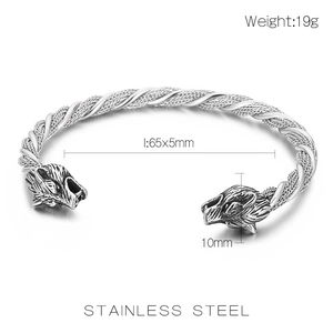 Macro shot of stainless steel woven texture and wolf head details on the silver cuff