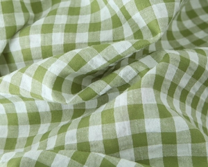 Detailed macro view of green and white gingham fabric texture and linen cotton material