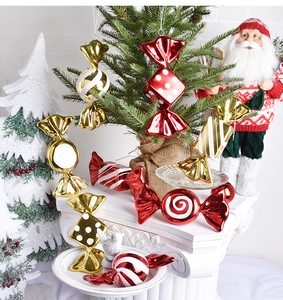 Detail of red and gold electroplated Christmas candy ornaments on a white marble tray