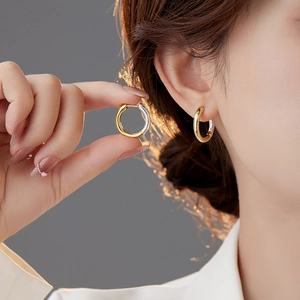 Minimalist two-tone gold and silver hoop earrings with a sleek mirror polished finish