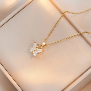 Primer plano de collar mariposa dorado con circonitas blancas en caja de joyas